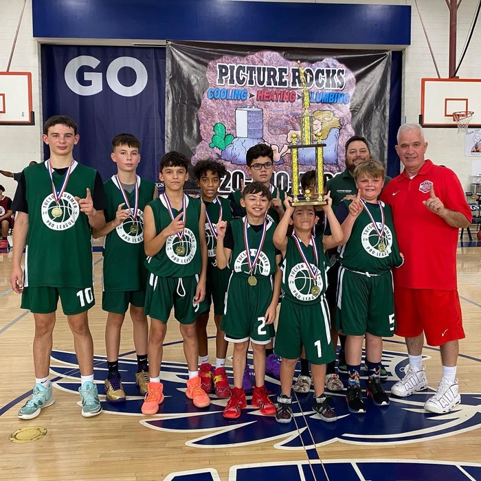 The boys youth basketball teams we support holding their trophy.