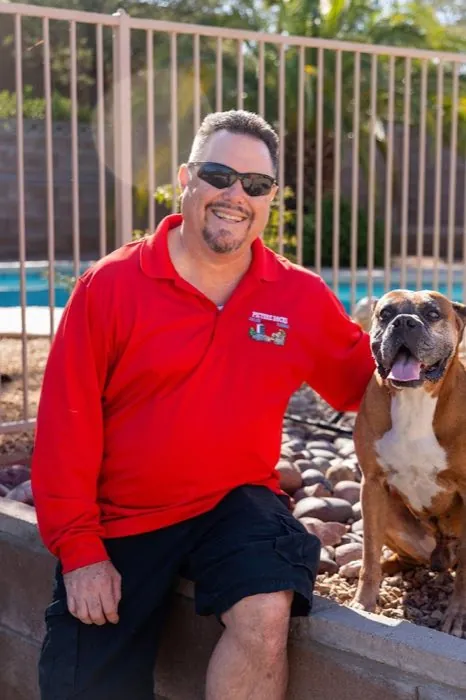 The owner of Picture Rocks Cooling with his boxer dog by a Tucson backyard pool