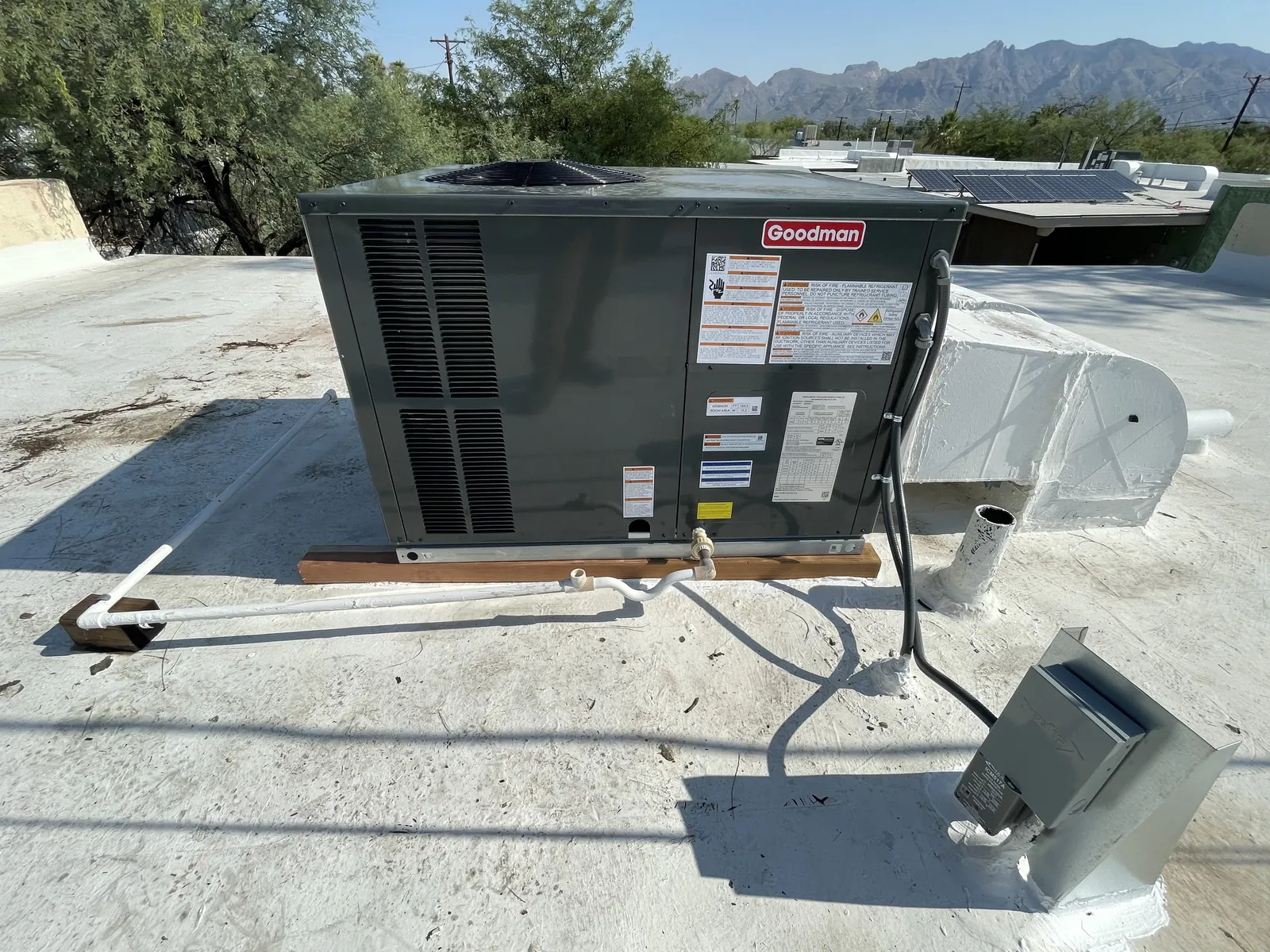 A newly installed rooftop gas pack on a Tucson flat roof with the Catalina Mountains behind.
